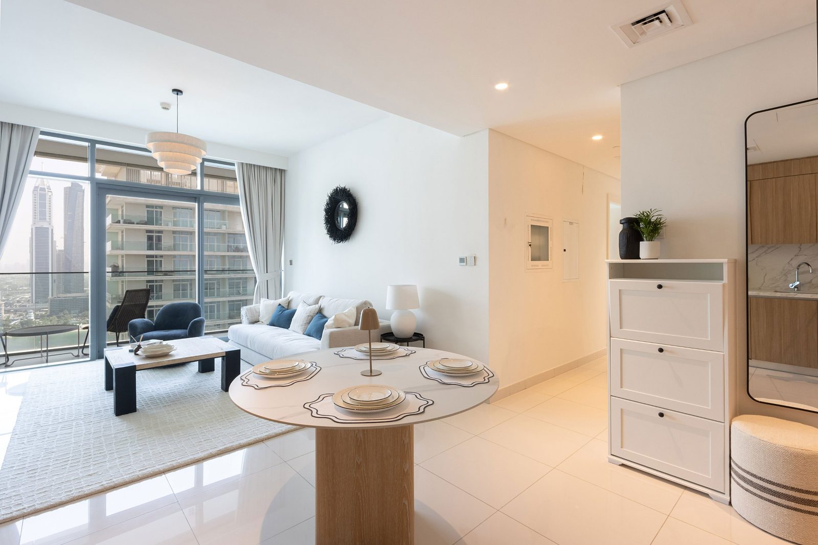 View from the front door of the Dubai Harbour apartment: round dining table, living room and the skyline beyond
