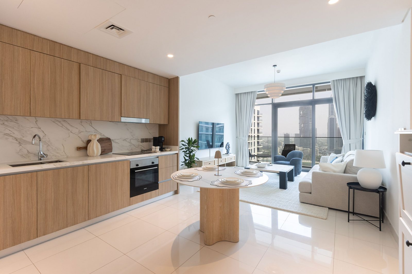 Open-plan kitchen, dining and living room of the furnished apartment, looking towards the window