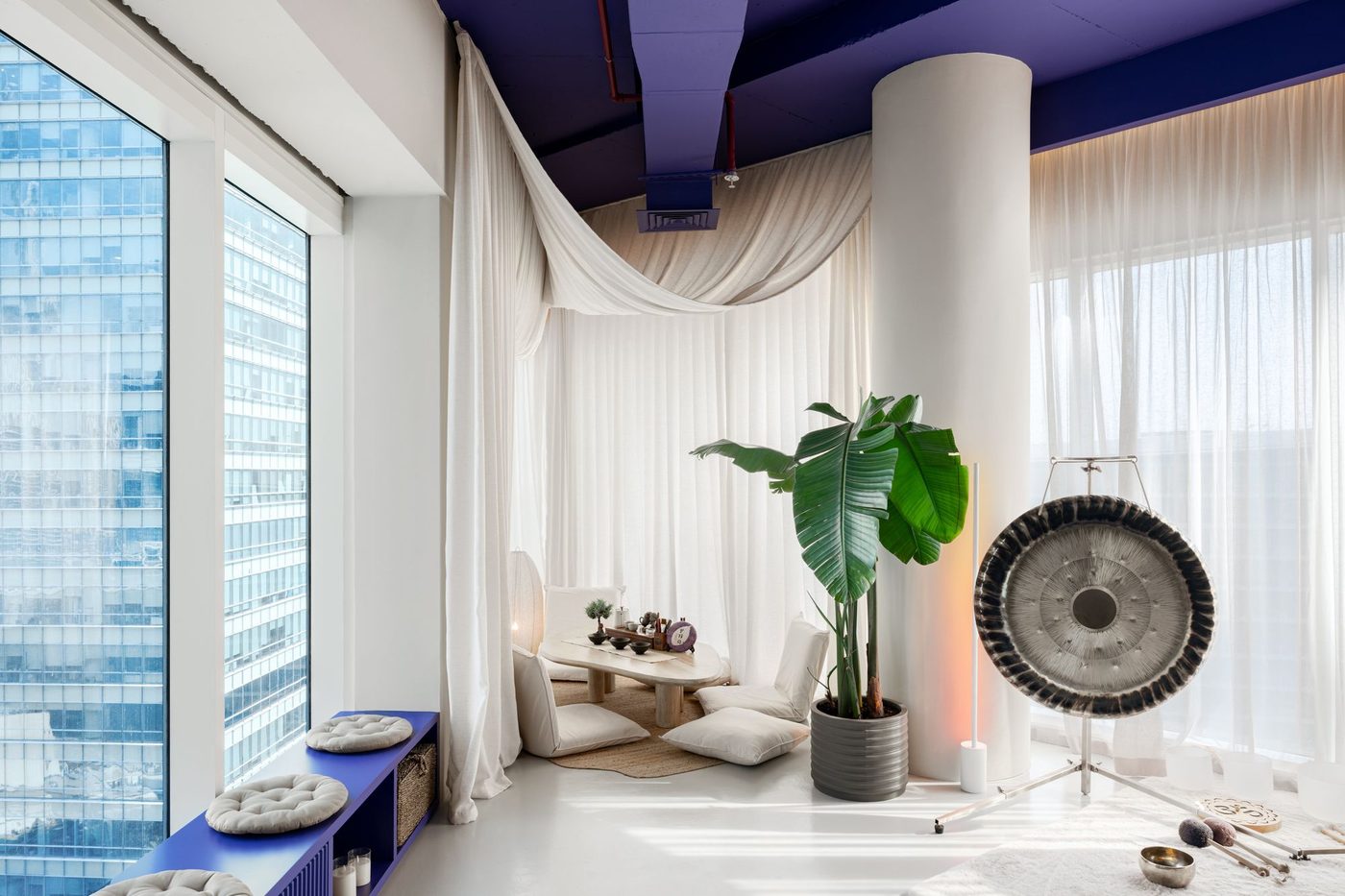 Tea area by the window with a gong and Business Bay towers outside